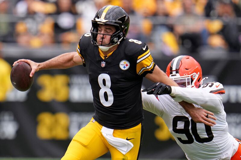 Pittsburgh Steelers quarterback Aaron Rodger (8) runs out of bounds with Cleveland Browns defensive end Joe Tryon-Shoyinka (90) defending during an NFL football game in Pittsburgh Sunday, Oct. 12, 2025. (AP Photo/Gene J. Puskar)