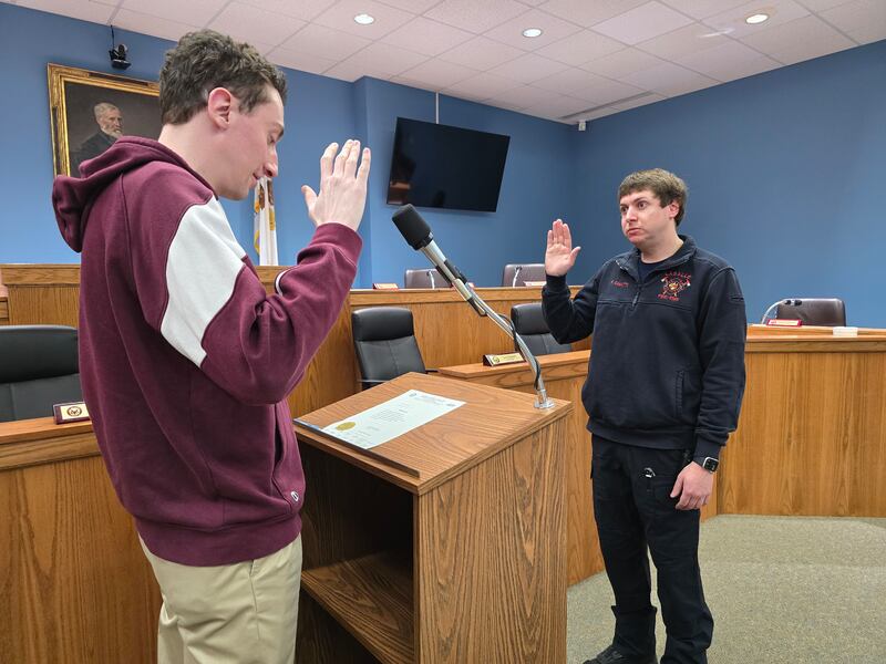 Kyle Camatti (right) takes the oath to become a full-time La Salle firefighter from the city's deputy clerk Brent Bader on Thursday, Feb. 27, 2024, at City Hall.