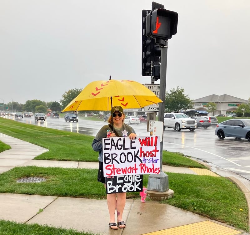 Elburn resident Jen Hall standing on Randall Road and Fargo Boulevard in Geneva Wednesday, Sept. 3 to protest Jan. 6, 2021 insurrection planner Stewart Rhodes as a guest speaker at Eagle Brook Country Club. The sponsoring group, The sponsoring group, Three Headed Eagle Alliance, announced a location change to be revealed closer to the Sept. 23 event where Rhodes will speak.