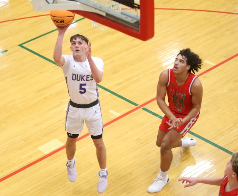 Dixon's Brady Feit runs in the lane to score on a layup over L-P's Marion Persich during the Class 3A Regional semifinal game on Wednesday, Feb. 26, 2025 in Sellett Gymnasium at L-P High School.