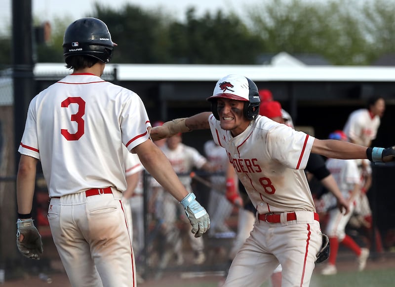 Huntley's Aiden Eickelmann (right) celebrates giving Huntley a two-run lead after coming home to score in the sixth inning of a Fox Valley Conference baseball game against McHenry on Tuesday, May 8, 2026, at Huntley High School.