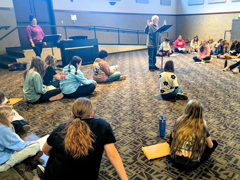 Students participating in Woodlawn Arts Academy’s spring musical, “Alice in Wonderland Jr.” rehearse music under the direction of Mardi Huffstutler, center, and Faith Morrison, back left.