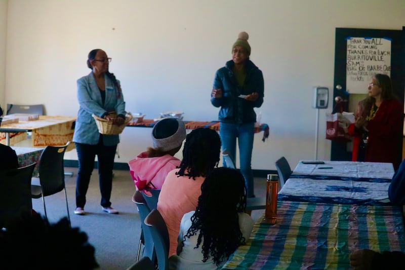 Shawnda Harris (center) is seen Nov. 15, 2025, speaking before fellow University Village residents on hand for a community meeting in DeKalb put on by DeKalb County Board members Rukisha Crawford (left) and Meryl Domina.