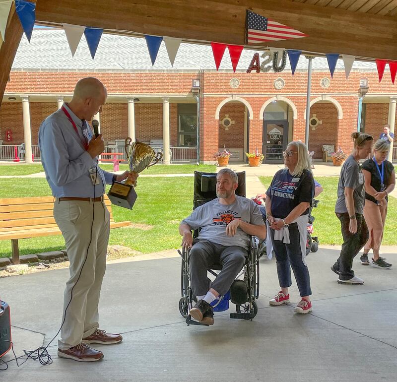 Illinois Department of Veterans Affairs Director Terry Prince, left, presents the Bike Across America trophy to the Green Team at the Manteno Veterans' Home on Sept. 2, 2025.