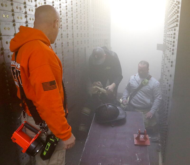 Training instructors prepare an injured firefighter training exercise on Tuesday April 15, 2025, during a RIT crew and chief divisional drill with other firefighters from area departments in a former bank building in Downtown McHenry.