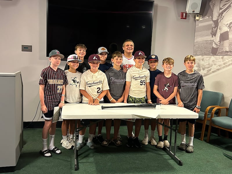 Members of the Morris Tomahawks 12U baseball team pose with the bat that Morris native Scott Spiezio used to hit a 3-run homer in Game 6 of the 2002 World Series.