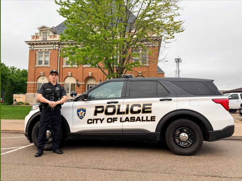 Officer Jessiel Moreno standing next to a La Salle Police Department squad car. Moreno recently completed his field training and will be out on solo patrol.