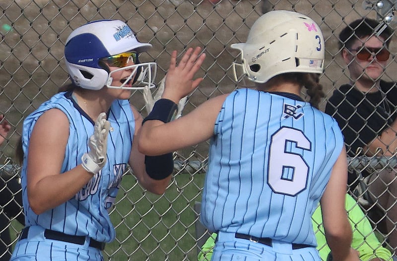 Bureau Valley's Emily Wright hi-fives teammate Ali Carington after both of them score back to back runs against Newman on Monday, March 30, 2026 at Bureau Valley High School.