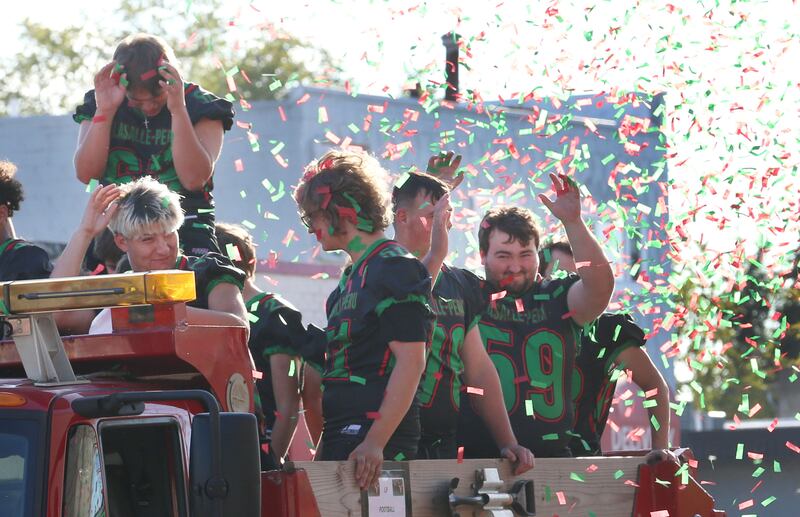 Members of the L-P football team are covered in red and green confetti during the L-P Homecoming parade on Thursday, Sept. 26, 2024 downtown La Salle.