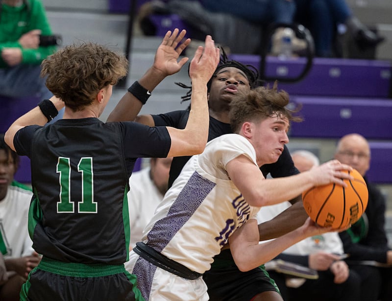 Dixon’s Jimi Gosinski works out of defense by Alleman’s Dylan Polich (left) and Dereon McDaniel Wednesday, Jan. 28, 2026.