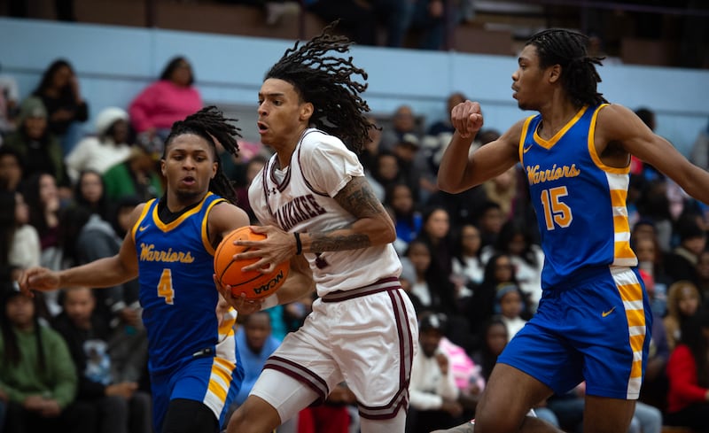 Kankakee's Lincoln Williams, center, controls the ball as Crete-Monee's Zyheir Gardner, left, and Kendle Cobb, right guard in a game on Friday, January 9, 2026.