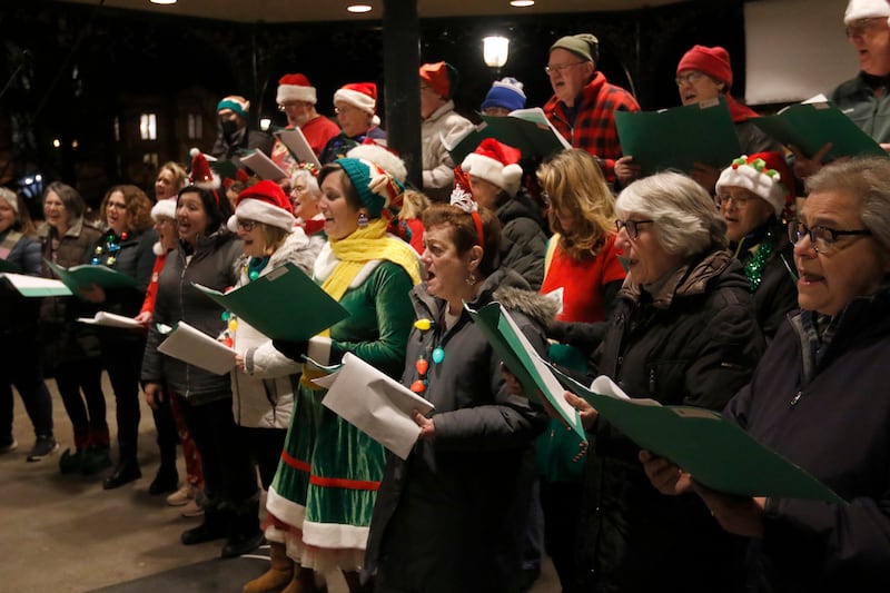 Members of the Woodstock Community Choir sing Christmas carols during the Lighting of the Square Friday, Nov. 25, 2022, in Woodstock. The annual event featured brass music, caroling, free doughnuts and cider, food trucks, festive selfie stations and shopping.