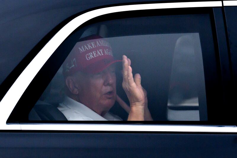 President Donald Trump waves from his vehicle as he arrives at the Trump International Golf Club, Monday, Feb. 17, 2025, in West Palm Beach, Fla. (AP Photo/Ben Curtis)