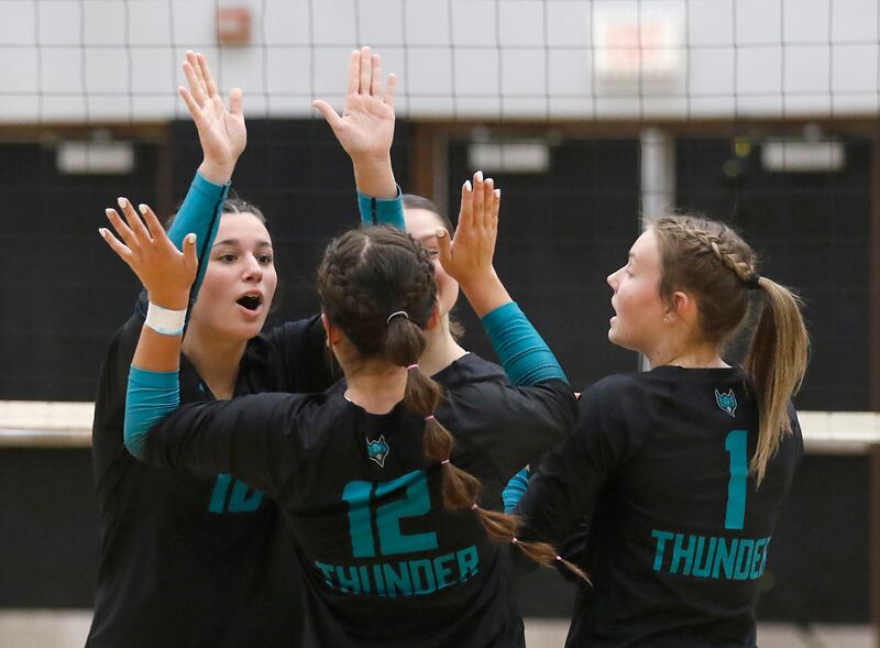 Woodstock North's Ava Kardaras, (left) Gabriella Schefke, (center) and Tayler Menzel (right) celebrate a point during a Kishwaukee River Conference volleyball match against Richmond-Burton on Monday, Sept. 15, 2025, at the Woodstock North High School.