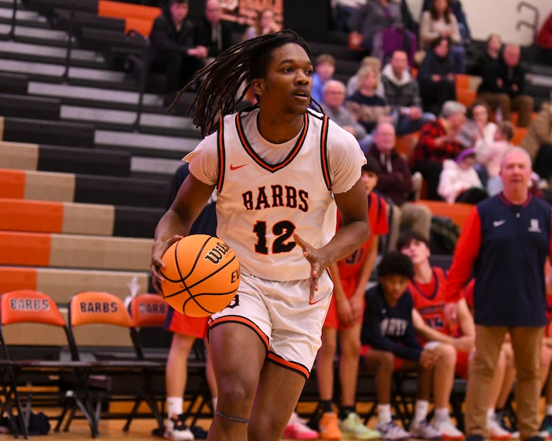 eKalb's Derrion Straughter (12) looks for an open teammate during the game on Friday Dec. 27, 2024, while taking on Belvidere North during the 97th Chuck Dayton Classic Basketball tournament held in DeKalb.