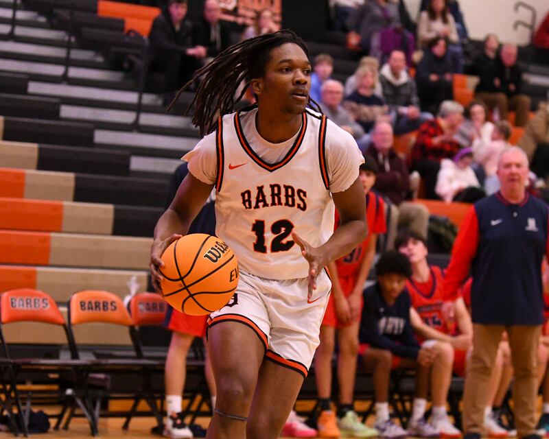 eKalb's Derrion Straughter (12) looks for an open teammate during the game on Friday Dec. 27, 2024, while taking on Belvidere North during the 97th Chuck Dayton Classic Basketball tournament held in DeKalb.