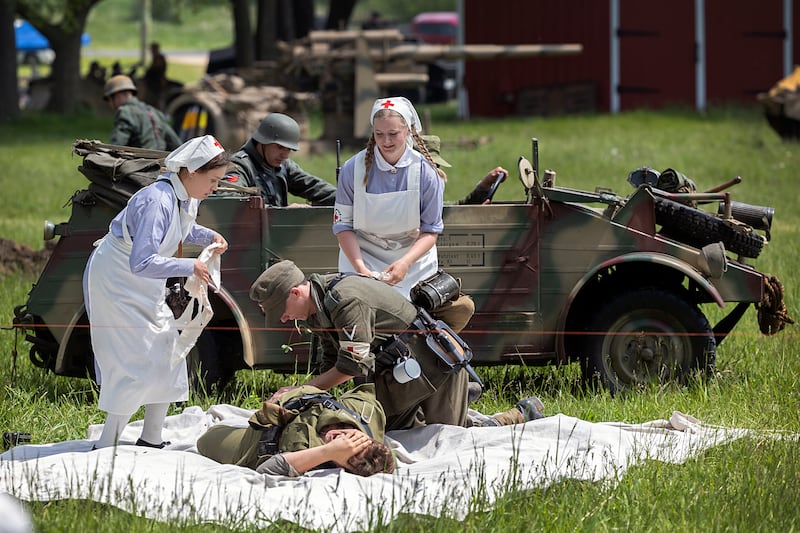 Medics tend to a victim Saturday, May 16, 2026, during a reenactment of the Battle of Anzio in Franklin Grove.
