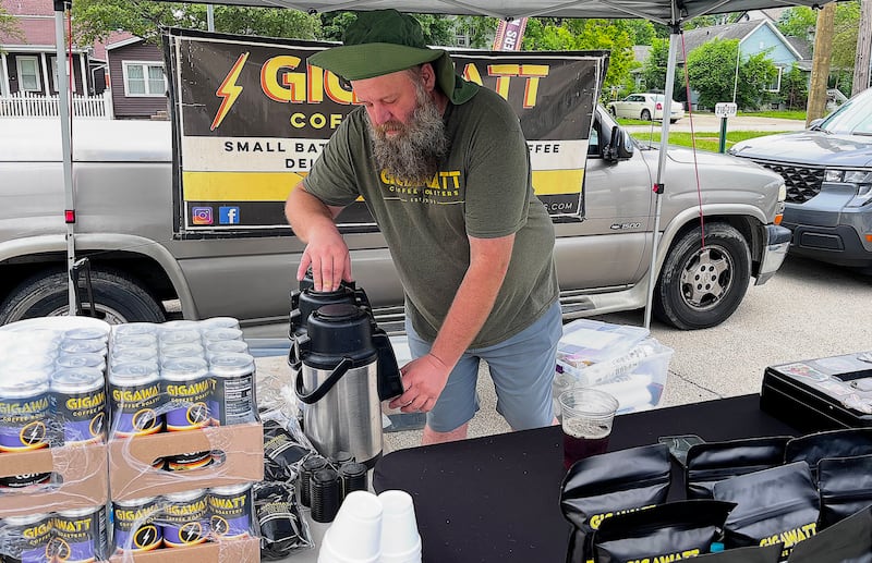 James Ravnic, lead roaster for Gigawatt Coffee Roasters, pours coffee for a customer on May 23, 2026 at Lockport Trackside Farmers Market.