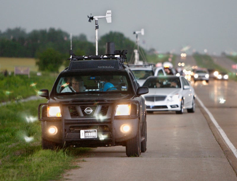 FILE - In this May 19, 2010 file photo taken near Kingfisher, Okla., storm chasers and spectator vehicles clog the road and shoulder of Highway 81. The subculture of chasing has gone mainstream in recent years, thanks to digital cameras and mobile radar. And it's getting more dangerous. Highways are increasingly clogged with chasers trying to beat each other in a risky race to capture the storms. Three storm chasers died Tuesday, March 28, 2017, in a collision as they raced toward a tornado-warned storm in West Texas, authorities said. (AP Photo/Sue Ogrocki, File)