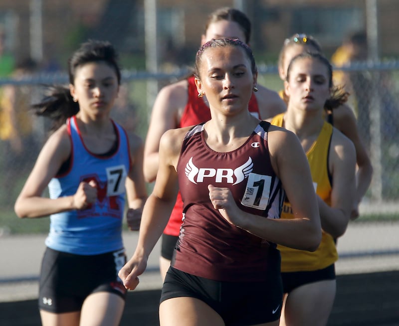 Prairie Ridge’s Anneke Dam leads the pack as she winning the 800 meter run on Thursday, April 23, 2026, during the McHenry County Track and Field Meet at McCracken Field in McHenry.