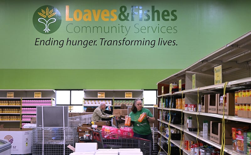 Volunteers including Katie Maxon stock shelves at the Loaves & Fishes food pantry in Naperville.