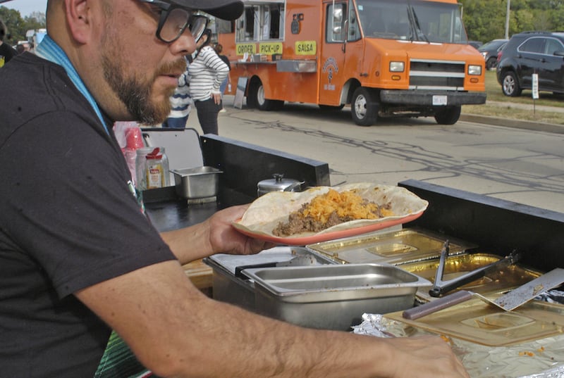 Carlos Garcia of Carlos' Tacos of Sterling puts finishing on a Super Taco at the Taco Throwdown Events Sponsored by Rock Falls Tourism. Event at RB&W District September 27th, 2024.