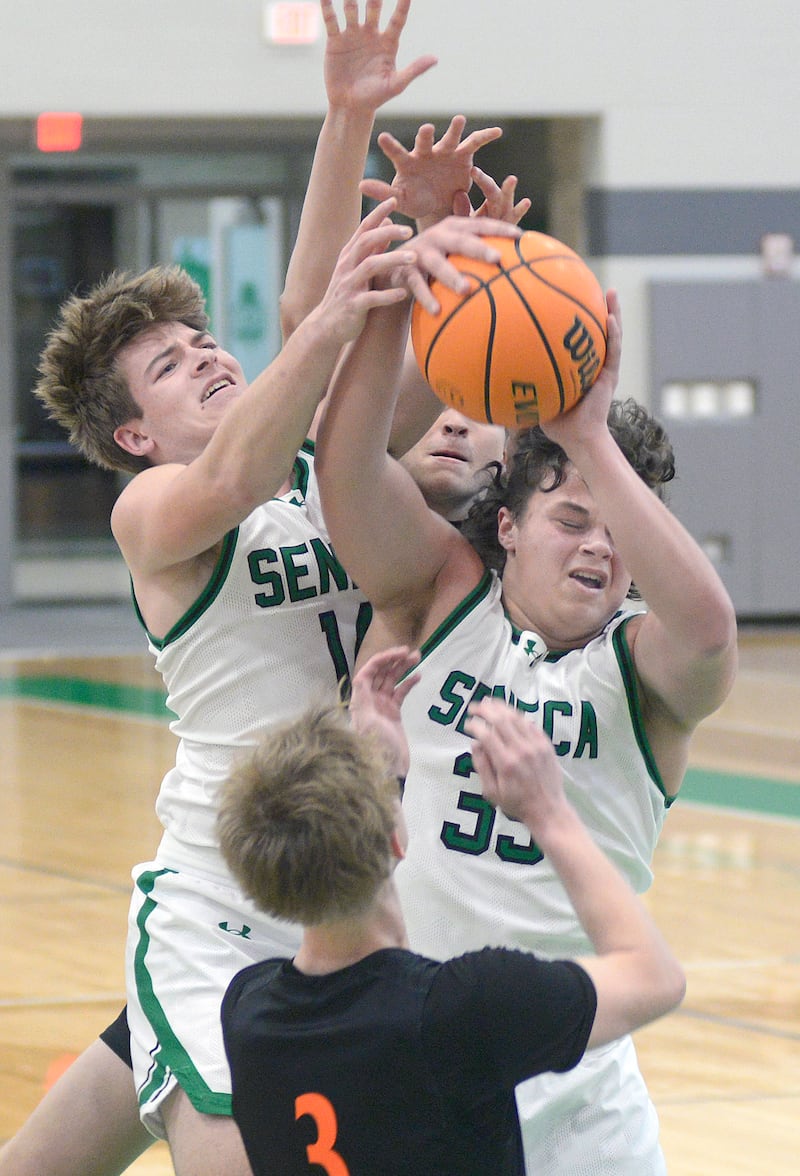 Seneca’s Cam Shriey and Zeb Maxwell fight for a rebound with Sandwich’s Wyatt Koley in the 1st period Saturday during the MLK Shootout at Seneca.