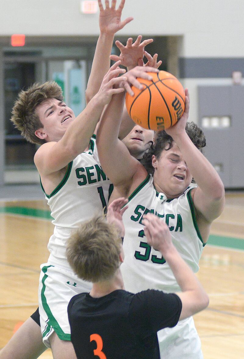 Seneca’s Cam Shriey and Zeb Maxwell fight for a rebound with Sandwich’s Wyatt Koley in the 1st period Saturday during the MLK Shootout at Seneca.