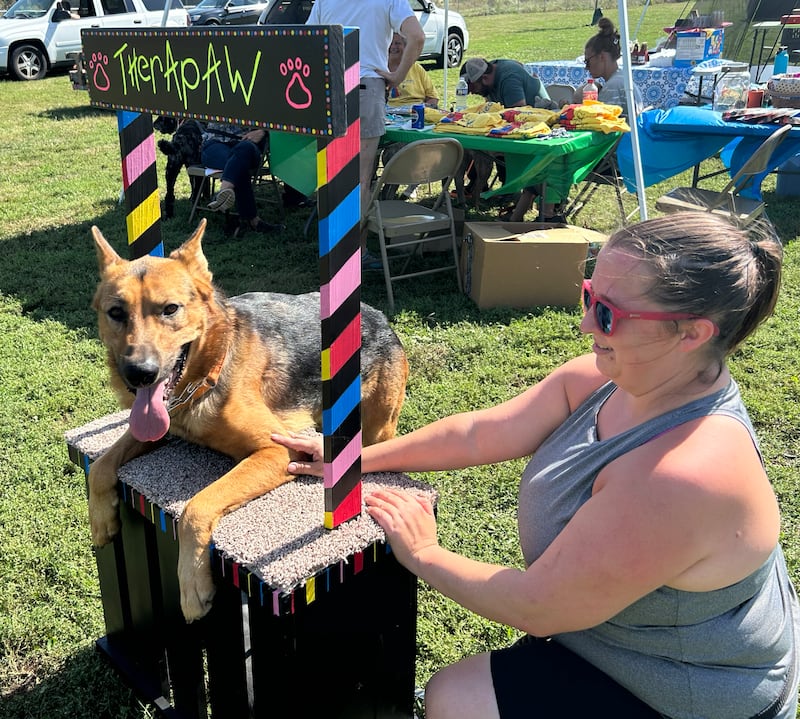 Hawkeye, who is up for adoption, lays in the "Kissing Booth" with Sandra Moore at the Bonafied Rescue Rally in Oregon on Saturday, Sept. 27, 2025.