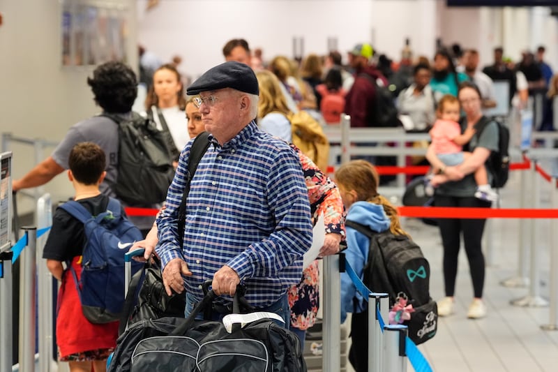 Travelers stand in line at a ticketing gate at the Dallas Fort Worth International Airport, at DFW Airport, Texas, Friday, Nov. 21, 2025. (AP Photo/Tony Gutierrez)