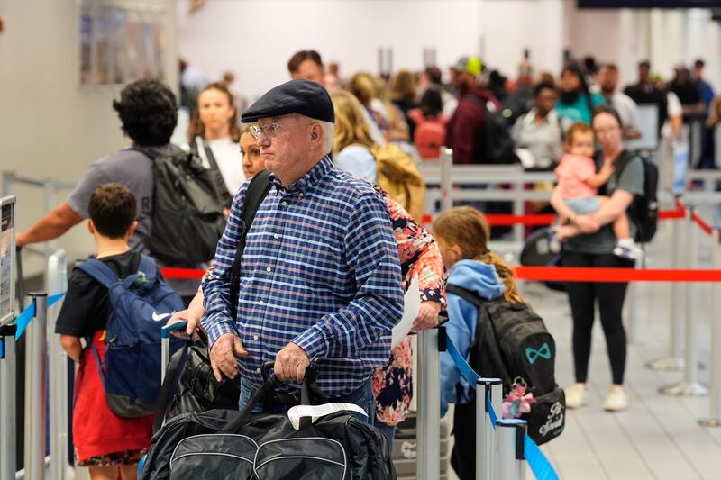 Travelers stand in line at a ticketing gate at the Dallas Fort Worth International Airport, at DFW Airport, Texas, Friday, Nov. 21, 2025. (AP Photo/Tony Gutierrez)