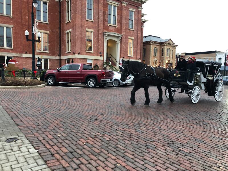 A carriage passes by the newly remodeled and reopened Old Courthouse on the Woodstock Square Dec. 17, 2023