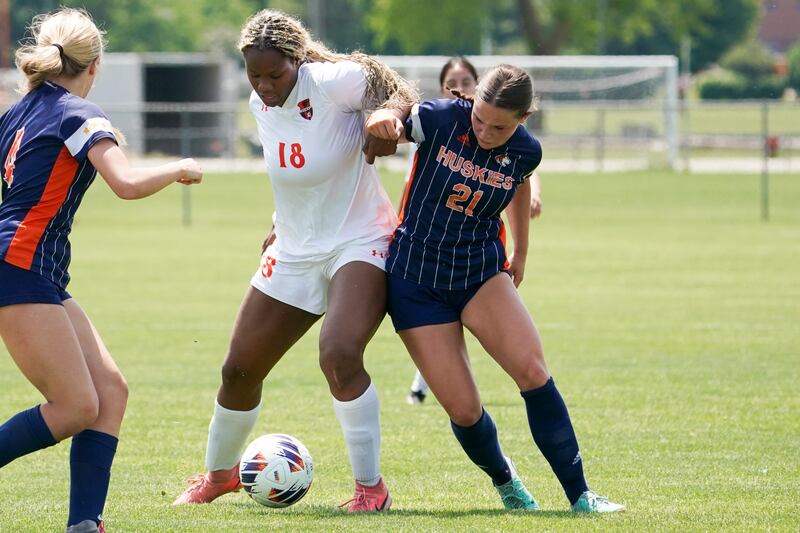 Oswego’s Jordyn Washington (18) challenges Naperville North's Emily Buescher (21) for the ball during a class 3A Oswego regional final match at Oswego High School on Saturday, May 24, 2025.