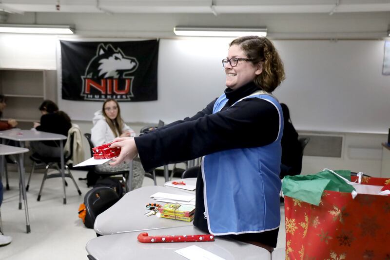 Kelsey Podgorski, assistant director of multilingual education at McHenry High School, delivers a pen pal's letter and Christmas present to one of the English lab students on Tuesday, Dec. 19, 2023.