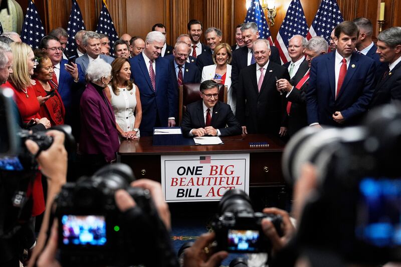 Speaker of the House Mike Johnson, R-Louisiana, surrounded by Republican members of Congress, signs President Donald Trump's signature bill of tax breaks and spending cuts, Thursday, July 3, 2025, at the Capitol in Washington.