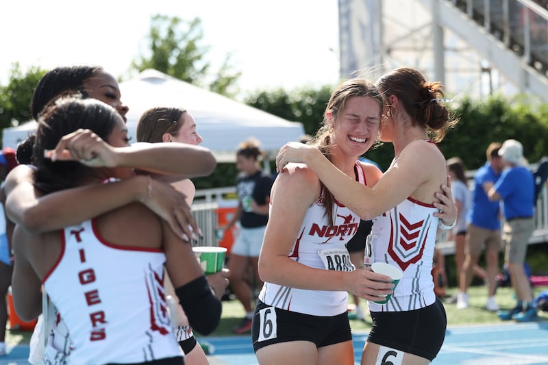 Plainfield North's Lindsey Wenz, second from right, hugs teammate Lauren Dellangelo, right, after the team secured first place in the 4x400 relay during the IHSA Class 3A Girls Track & Field State Finals on Saturday, May 24, 2025.