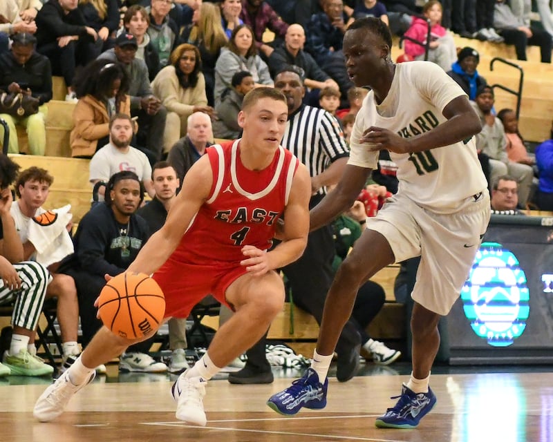 Glenbard East's Michael Nee (4) tries to dribble around Glenbard West's defender Josh Abushanab (10) on Wednesday Nov. 26, 2025, during the District 87 Thanksgiving Invitational held at Glenbard West High School.