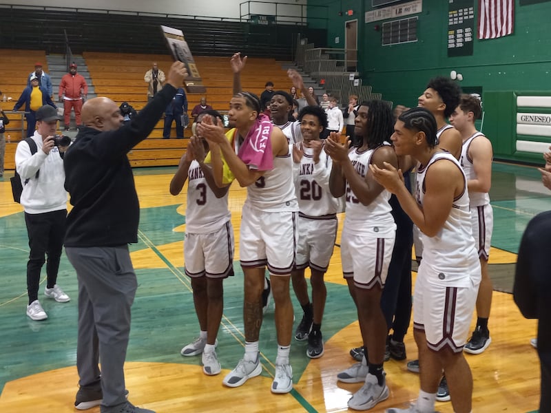 Kankakee head coach Chris Pickett brings the regional plaque over to his team after the Kays' 93-41 win over Plano in the IHSA Class 3A Geneseo Regional championship on Feb. 27, 2026.