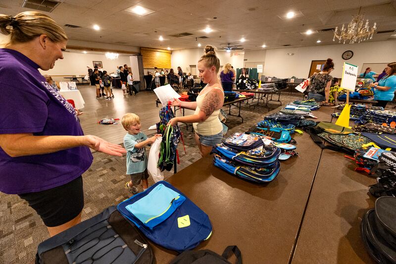 Kim Bork (left), helps mom Alysha Boettger shop for Cooper Full, 5, Thursday, August 7, 2025, at Dixon School’s Tools for School giveaway.