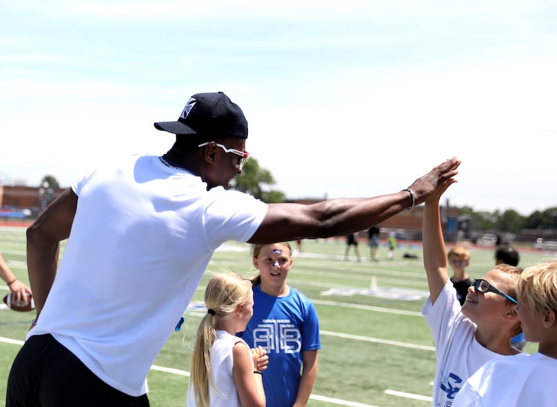 Former St. Charles North standout and current New York Giants defensive back Tyler Nubin high-fives Pryce Hendriksen, 10, on the first day of a three-day football camp on Friday, June 20, 2025 in St. Charles.