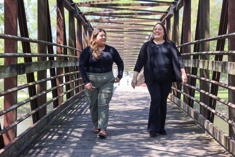 Lizbeth Varela, left, walks with her mother Natalie Ojeda, both of Momence, across the Momence Island Park bridge last week. The mother-daughter duo are now both involved in local government, with Ojeda beginning her second term as the Momence Park District president and Varela, 22, recently being sworn as a member of the Momence School Board.