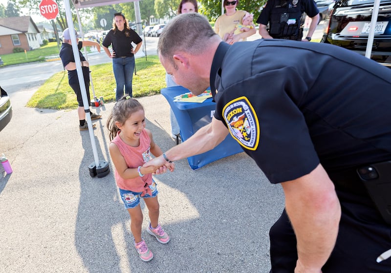 Arabella Short, 4, of Dixon excitedly shakes the hand of Dixon Chief of Police Ryan Bivins on Tuesday, August 5, 2025, at National Night Out.