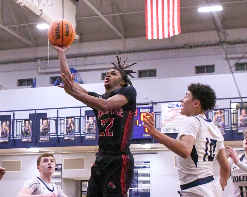 Yorkville's Braydon Porter (22) takes a shot during the game while being defended by a pack of Oswego East players during the game on Friday Feb. 14, 2025, held at Oswego East High School.