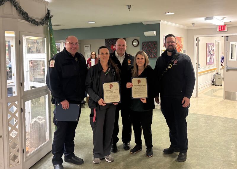 Plainfield Fire Protection District (back row from left) Fire Marshal Ryan Angelus, Chief Vito Bonomo III and Fire Inspector Adam Moble honored Lakewood Nursing Home staff Roberta Ceh, Shannon Delrio (pictured), and Dimond Hill (not pictured) on Dec. 8, 2025.