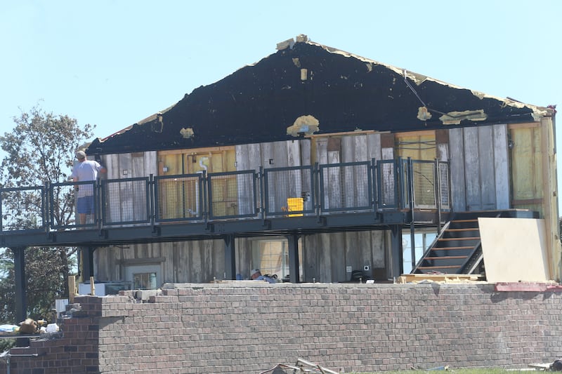 A worker looks at a wall that all remains form a barn that was demolished by a tornado in the 1300 block of Airport Road on Monday, June 15, 2026 in Streator.