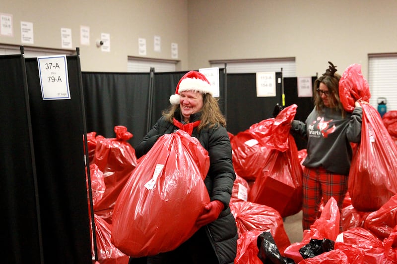 Jill Caccia (left) and Becky Brandt (right) carries a bag full of gifts for one of 550 St. Charles School District 303 children on Tuesday, Dec. 3, 2024 for the annual Big Hearts of Fox Valley Christmas Gift Sponsorship Program.