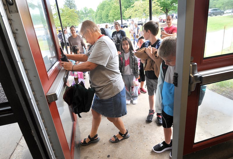 Office assistant Cindy Kepka props the door open for waiting students on the first day of classes at Yorkville Grade School on Friday, Aug. 15, 2024.
