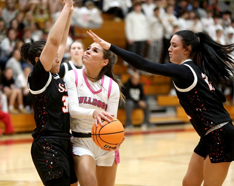 Batavia's Hallie Crane attempts a shot between St. Charles East's Corinne Reed (left) and St. Charles East's Sofia O’Sullivan during a game on Thursday, Feb. 6, 2025 in Batavia.