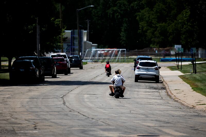 Motorbike riders travel along Lincoln Statue Drive in front of Dixon High School on Tuesday, June 17, 2025, after crossing the Peoria Avenue bridge. City officials have seen an uptick of calls from concerned residents regarding the bikes.