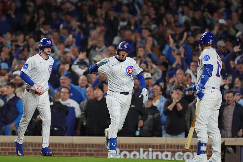 Chicago Cubs' Ian Happ (8), middle, celebrates after hitting a 3-run home run during the first inning of Game 4 of baseball's National League Division Series against the Milwaukee Brewers Thursday, Oct. 9, 2025, in Chicago. (AP Photo/Nam Y. Huh)